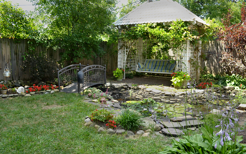 overall view of stream and swing in pergola in Snyder NY backyard