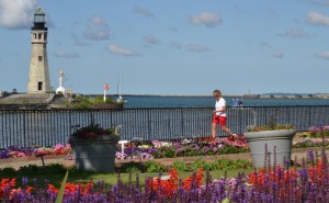 woman walking by test gardens at Erie Basin Marina
