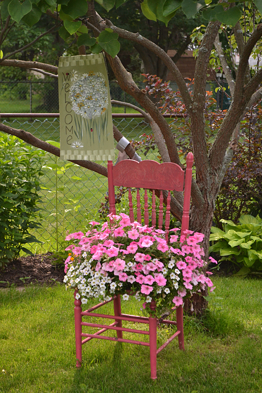 chair with pink annuals as garden art in Lockport NY